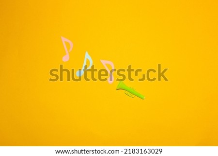 green trumpet playing on yellow background