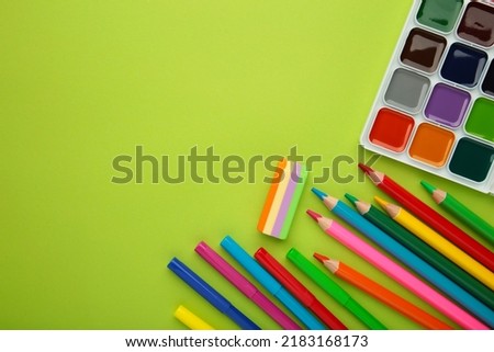 Different stationery on green background, flat lay with space for text.