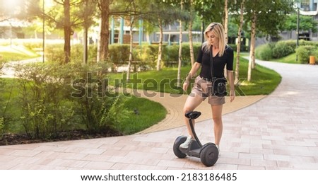Beautiful woman stand near segway or hoverboard. self balancing electrical scooter. Royalty-Free Stock Photo #2183186485