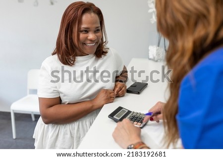 A black woman client smiles while waiting at the dental clinic