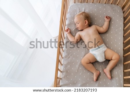 Upper view copy space portrait of cute blond baby sleeping in bed on his back, feeling safe, watching sweet dreams, resting, growing, gaining strength, getting strong. Childcare concept. Nap time Royalty-Free Stock Photo #2183207193