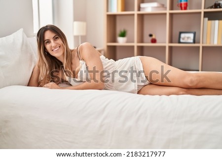 Young woman smiling confident lying on bed at bedroom