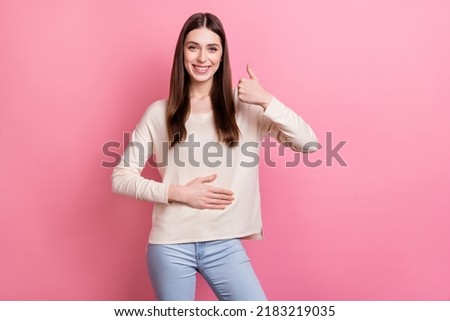 Portrait of attractive cheerful brown-haired girl touching belly showing thumbup isolated over pink pastel color background Royalty-Free Stock Photo #2183219035