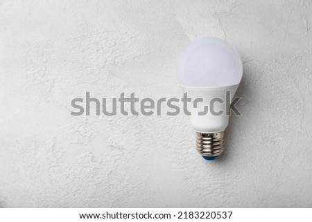 LED lamp energy efficiency concept. Composition on white cement background. Use economical and environmentally friendly light bulb concept.Eco. flat lay.copy space.MOCKUP