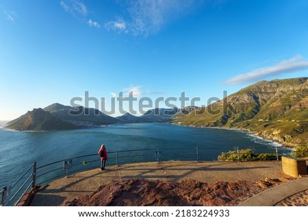 Tourist at the  Chapman's Peak Drive view site taking photographs towards Hout Bay. Cape Town. Western Cape. South Africa Royalty-Free Stock Photo #2183224933