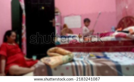 blurry photo of a pregnant mother accompanying her child to play in the bedroom