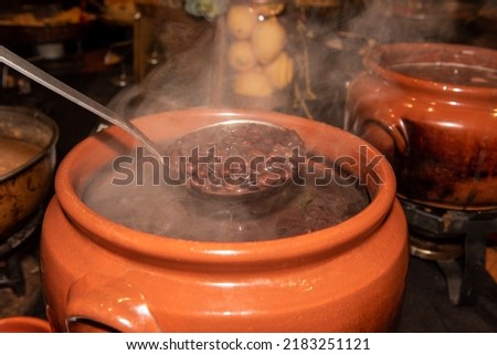 Delicious black beans pot. The brazilian typical food called feijoada is made with black beans. Royalty-Free Stock Photo #2183251121