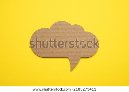 Speech bubble crepe paper balloon label on yellow background Royalty-Free Stock Photo #2183273411