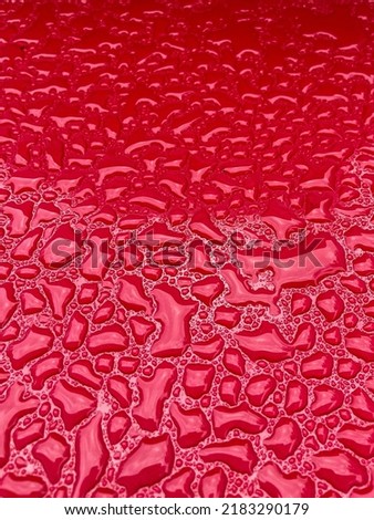 Fresh water droplets on a red grill after rainfall