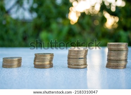 Stack of coins on blurry nature background. Business growth concept idea photo.