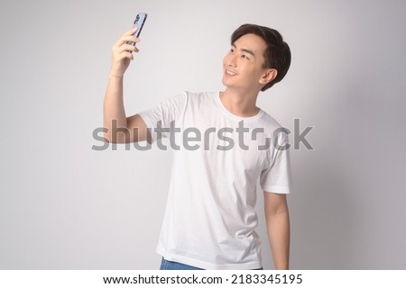 A Young asian man using smartphone over white background, technology concept. 		