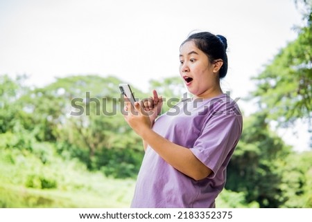 Shocked Asian woman taking pictures like with a phone