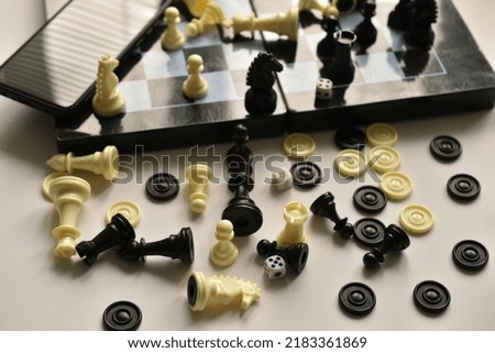 The picture shows a table and a chess board on which forgotten chess pieces lie mixed.