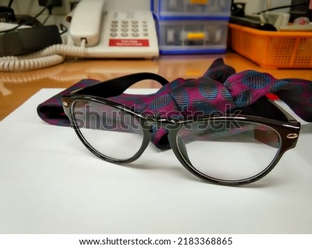 not focus, grainy photo of glasses with black frames on a glass table