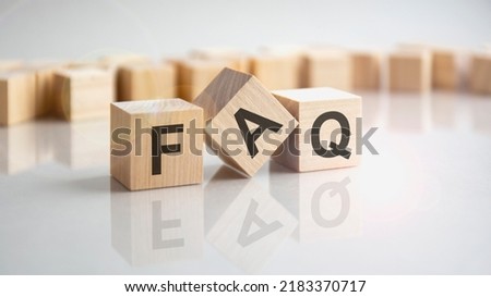text faq on wooden blocks with letters on a gray background. reflection of the caption on the mirrored surface of the table. Royalty-Free Stock Photo #2183370717