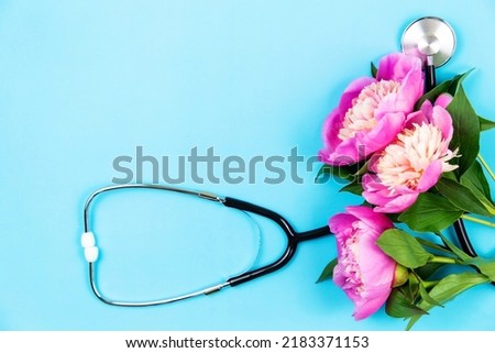 Stethoscope with flowers on a blue background. Medical background