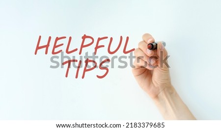 Hand with marker writing the word Helpful Tips.