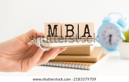 MBA - Master of Business Administration. Wooden letters spelling. MBA writting on wooden cubes on financial documents background.