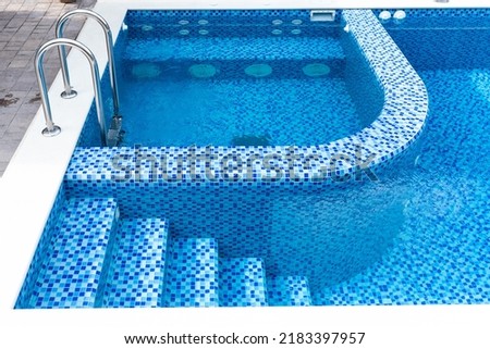 Swimming pool with blue tiles. Steps and separate jacuzzi area. Relax in the backyard of a country house