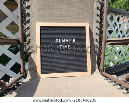A sign saying summer time. The felt sign has removable letters than can be moved around to make whatever words or saying one wants. 
