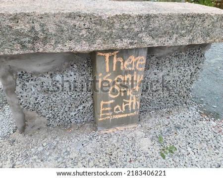 A sign attached to a stone saying that there is only one Earth.