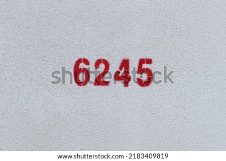Red Number 6245 on the white wall. Spray paint.
