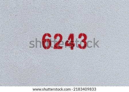 Red Number 6243 on the white wall. Spray paint.
