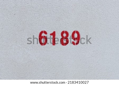 Red Number 6189 on the white wall. Spray paint.
