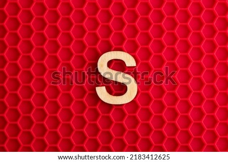 Alphabet letter S - White piece on silicone background with red hexagons