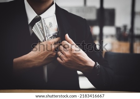 The concept of corruption, the law, the hands of the bureaucrats Put a large amount of money in your pocket after signing important documents to benefit private companies. Royalty-Free Stock Photo #2183416667