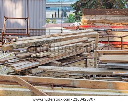 A pile of wooden planks at a construction site.