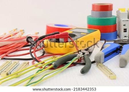 Multimeter and tools for installing an electrical control panel in close-up. 