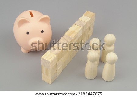 Banned access to money concept. People figures and piggy bank separated by wall.