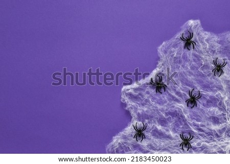 Happy Halloween composition with spiderwebs and spiders on very peri purple background. Halloween party greeting card mockup. Copy space. Flat lay, top view