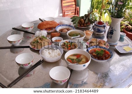 A tray of rice on the day of commemoration in a rural area of Vietnam. Including sour soup, mushroom-cooked chicken, beef stock, oversized soup, bread, etc.