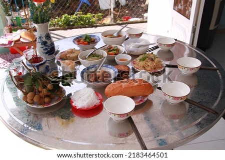 A tray of rice on the day of commemoration in a rural area of Vietnam. Including sour soup, mushroom-cooked chicken, beef stock, oversized soup, bread, etc.