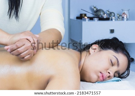 Real spa day, with hot stones and professional manual massages. Young woman, Hispanic brunette. 