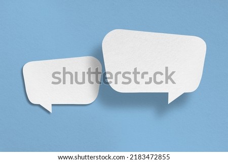 white paper with speech bubbles isolated on blue background communication bubbles design. Royalty-Free Stock Photo #2183472855