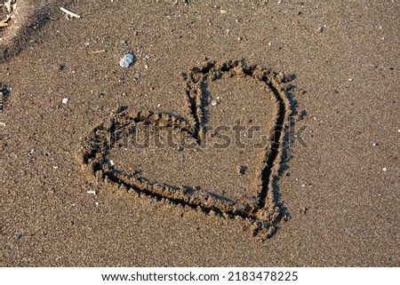 Heart icon drawn on the sandy beach.