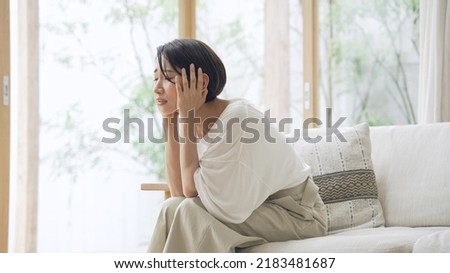 Depressed Asian middle aged woman in the room. Royalty-Free Stock Photo #2183481687