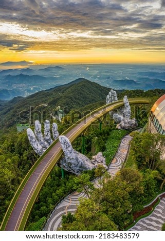 Aerial view of the Golden Bridge is lifted by two giant hands in the tourist resort on Ba Na Hill in Da Nang, Vietnam. Ba Na mountain resort is a favorite destination for tourists Royalty-Free Stock Photo #2183483579