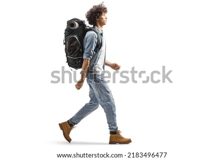 Full length profile of a young male traveler walking with a backpack isolated on white background Royalty-Free Stock Photo #2183496477