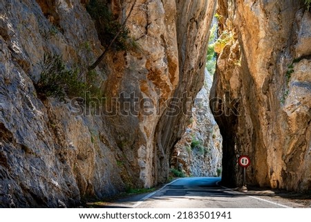 The narrow pass road MA-2141 to Sa Calobra village leads through a dangerous bottleneck at the famous high cliff gap Sa Bretxa rock gate in the mountain range of Serra de Tramuntana at Mallorca.