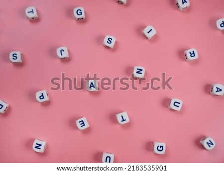  cubes or blocks word with letters randomly on a pink background - the concept of a newborn girl , school education or self education . Royalty-Free Stock Photo #2183535901