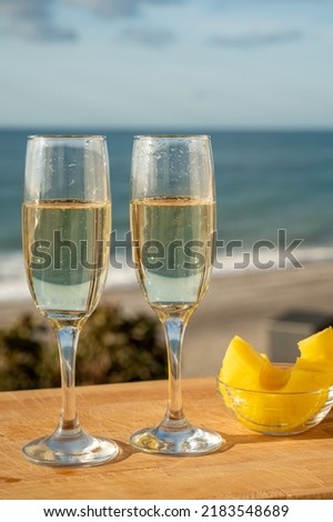 Outdoor breakfast in sunny day with Spanish cava sparkling wine and pineapple and view on blue sea and sandy beach in Marbella, Costa del Sol vacation destination, Andalusia, Spain