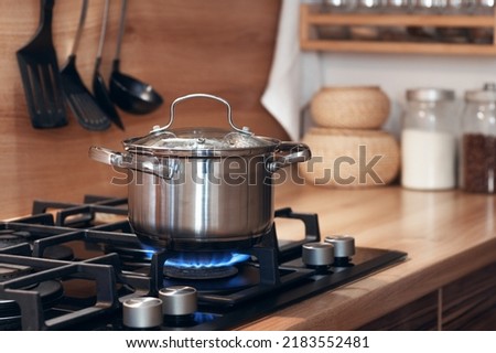 stainless pan on the hob, cooking on a gas stove, the cost of gas in Europe Royalty-Free Stock Photo #2183552481