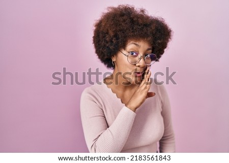 Young african american woman standing over pink background hand on mouth telling secret rumor, whispering malicious talk conversation  Royalty-Free Stock Photo #2183561843
