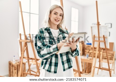 Young artist student girl smiling happy painting at art studio.