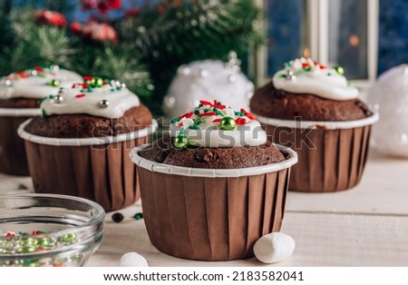 Chocolate Christmas cupcake with colored sugar topping on whithe wooden background. Selective focus