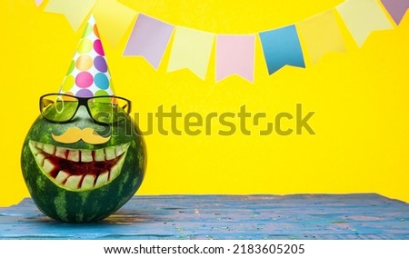 Funny watermelon in festive garlands for congratulations on any holiday. Copy space watermelon with smile character. Happy birthday for any age Royalty-Free Stock Photo #2183605205